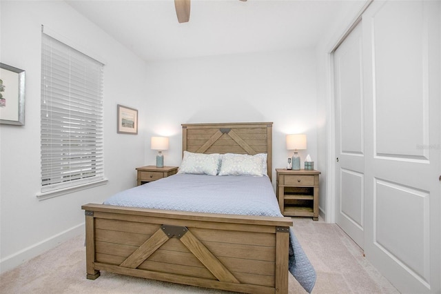 bedroom with a ceiling fan, light colored carpet, and baseboards