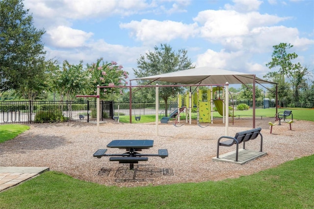 community playground featuring a yard and fence