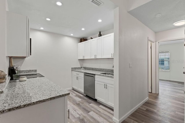 kitchen featuring light hardwood / wood-style flooring, dishwasher, light stone counters, white cabinets, and sink