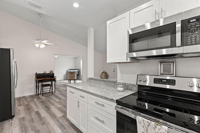 kitchen featuring vaulted ceiling, light hardwood / wood-style floors, stainless steel appliances, white cabinets, and light stone countertops