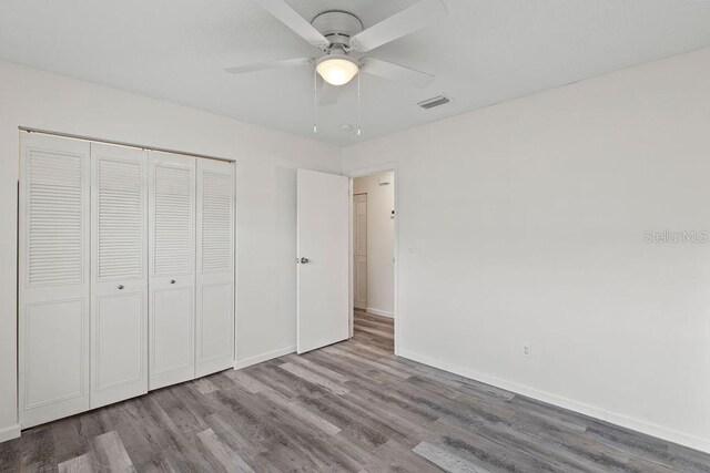 unfurnished bedroom featuring a closet, ceiling fan, and light hardwood / wood-style flooring