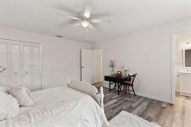 bedroom with a closet, ensuite bathroom, hardwood / wood-style floors, and ceiling fan