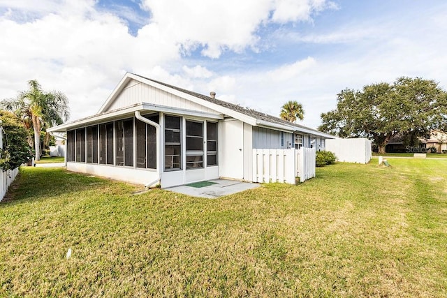 rear view of property with a yard and a sunroom