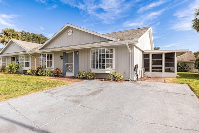 ranch-style home featuring a front lawn and a sunroom