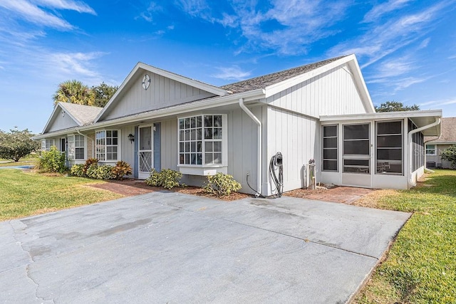 view of front of property with a front yard and a sunroom