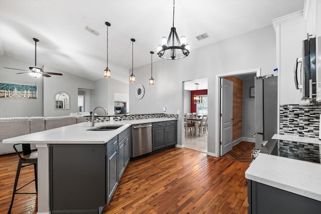 kitchen featuring visible vents, appliances with stainless steel finishes, open floor plan, vaulted ceiling, and a sink