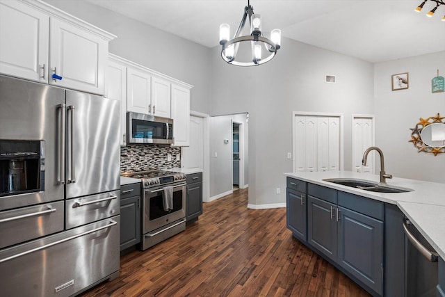 kitchen featuring dark wood-type flooring, a sink, white cabinetry, light countertops, and appliances with stainless steel finishes