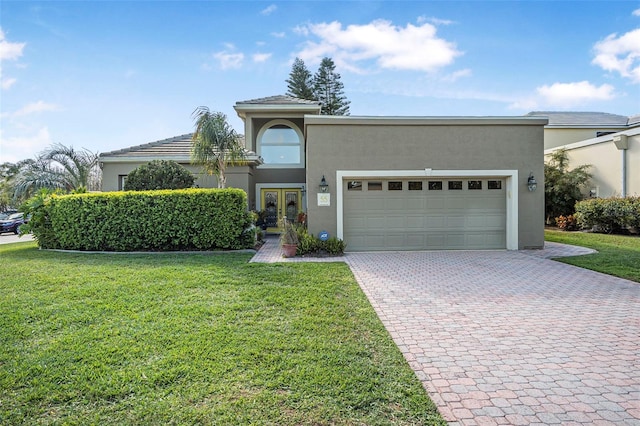 view of front of property featuring french doors, decorative driveway, stucco siding, an attached garage, and a front lawn