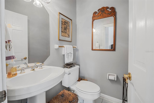 bathroom with baseboards, a sink, toilet, and tile patterned floors