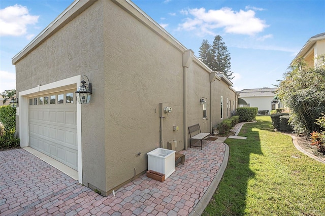 view of property exterior featuring a yard, an attached garage, and stucco siding