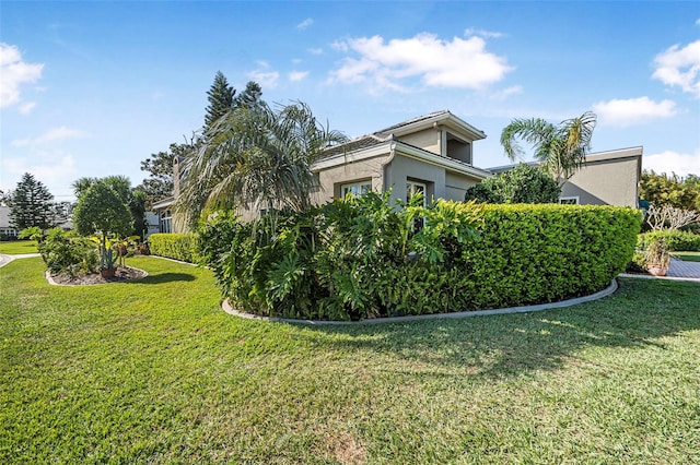 view of home's exterior with a yard and stucco siding