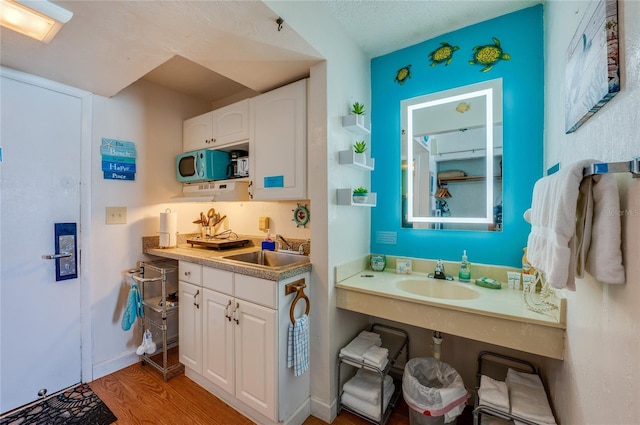 bathroom with a sink, baseboards, and wood finished floors