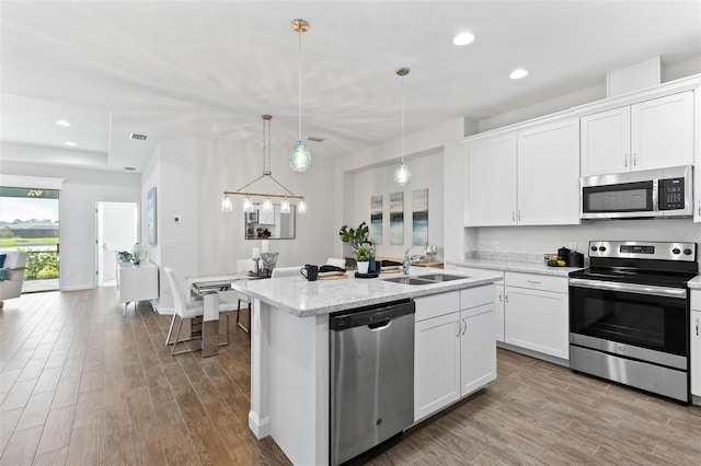 kitchen featuring sink, a center island with sink, appliances with stainless steel finishes, and white cabinets