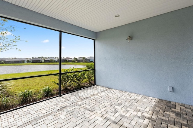 unfurnished sunroom featuring a water view