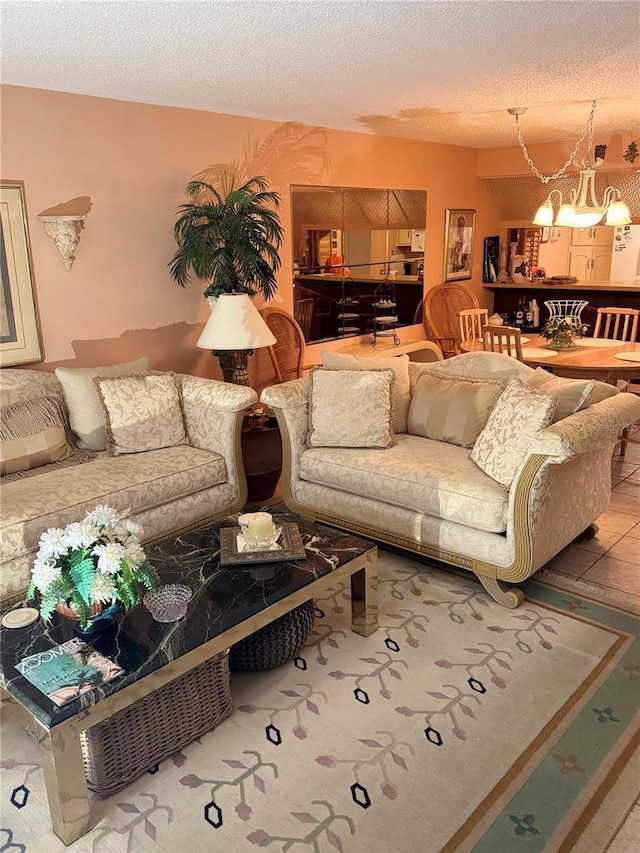 living room featuring a textured ceiling, tile patterned flooring, and a notable chandelier