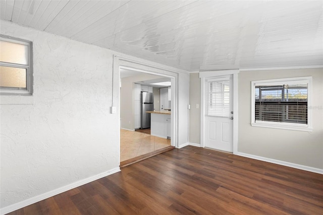 entryway with a textured wall, baseboards, and wood finished floors