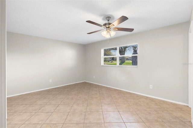 empty room featuring a ceiling fan and baseboards