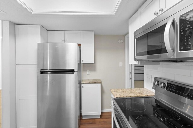 kitchen with light stone countertops, white cabinetry, and appliances with stainless steel finishes