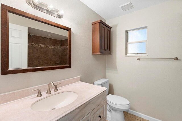 full bath featuring visible vents, toilet, tile patterned flooring, a tile shower, and vanity