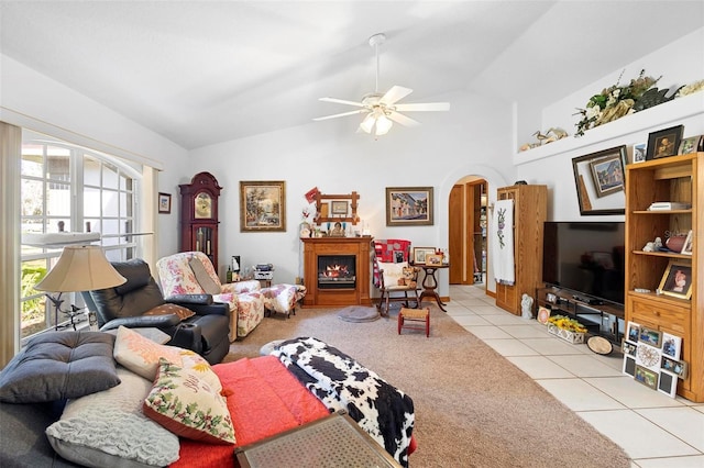 living room featuring lofted ceiling, light tile patterned flooring, and ceiling fan