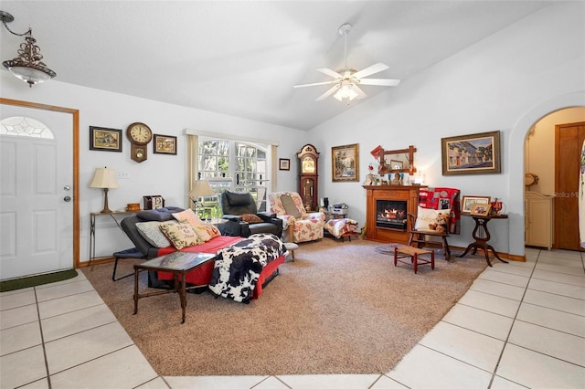 living room with vaulted ceiling, ceiling fan, and light tile patterned floors