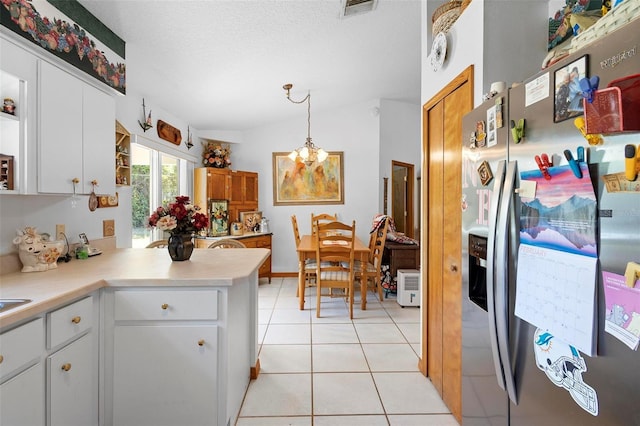 kitchen featuring hanging light fixtures, lofted ceiling, stainless steel refrigerator with ice dispenser, light tile patterned floors, and white cabinetry