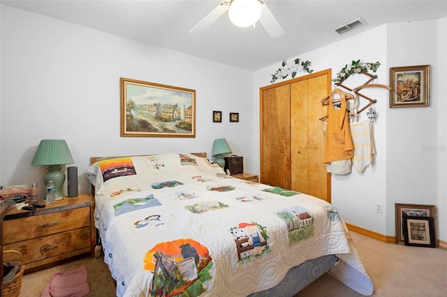 bedroom featuring carpet floors, a closet, a textured ceiling, and ceiling fan