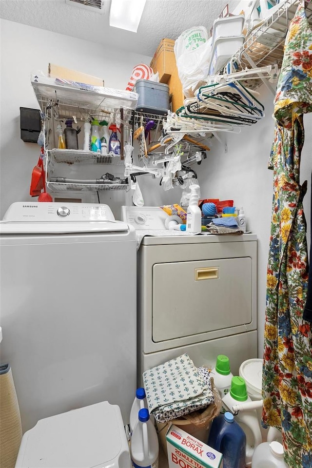 laundry room with washing machine and dryer and a textured ceiling