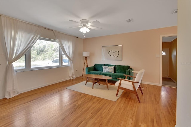 living area featuring visible vents, ceiling fan, light wood-style flooring, and baseboards