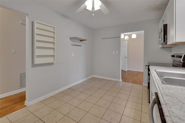 kitchen featuring visible vents, baseboards, ceiling fan, appliances with stainless steel finishes, and white cabinetry