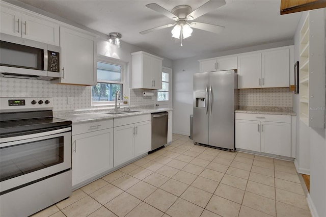 kitchen featuring stainless steel appliances, tasteful backsplash, a sink, and white cabinets