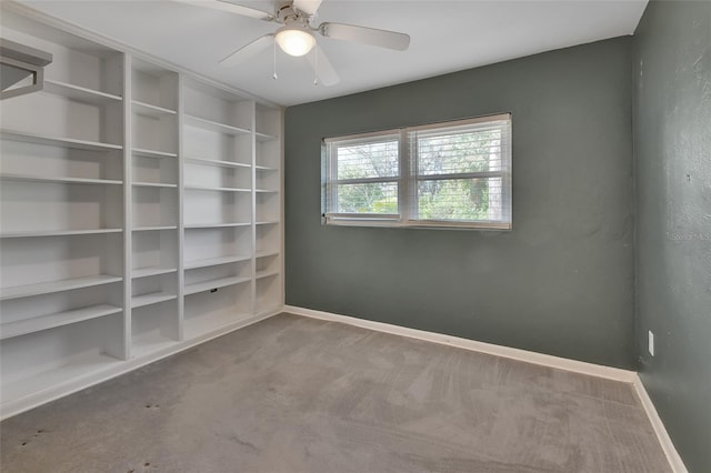 carpeted empty room featuring baseboards and a ceiling fan