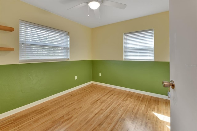 empty room with light wood-style flooring, baseboards, and a ceiling fan