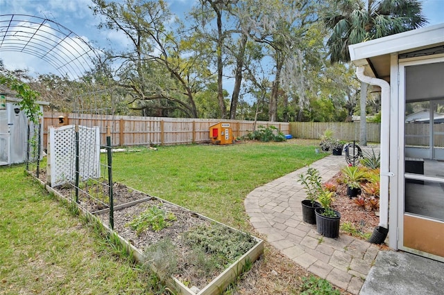 view of yard featuring a patio area, a fenced backyard, and a garden