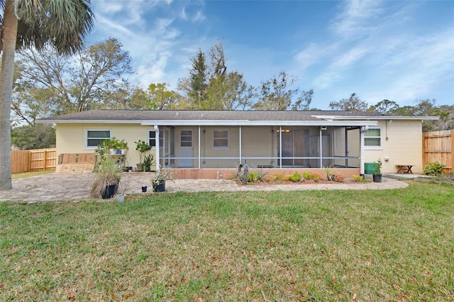 back of house with a sunroom, a patio area, fence, and a yard