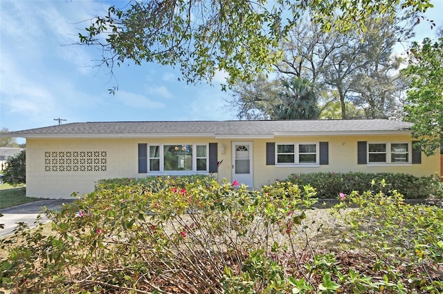 ranch-style house featuring roof with shingles