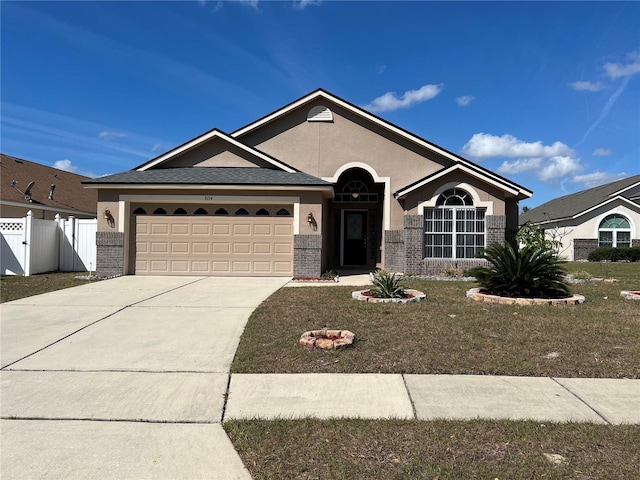 single story home featuring brick siding, driveway, an attached garage, and fence