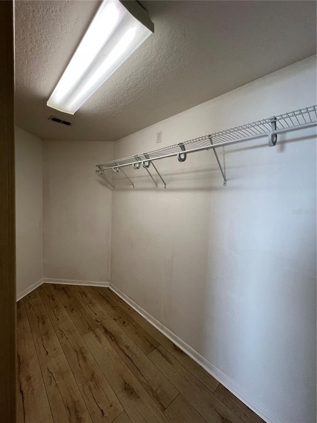 spacious closet featuring visible vents and wood finished floors