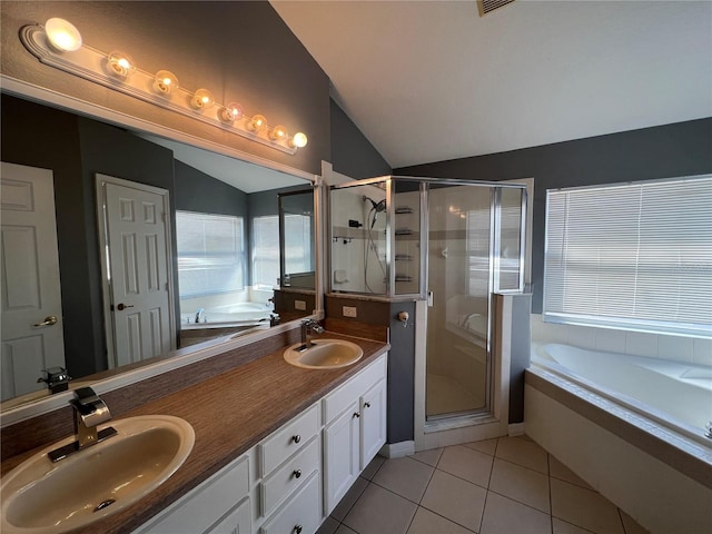 full bathroom featuring a garden tub, vaulted ceiling, a sink, and tile patterned floors