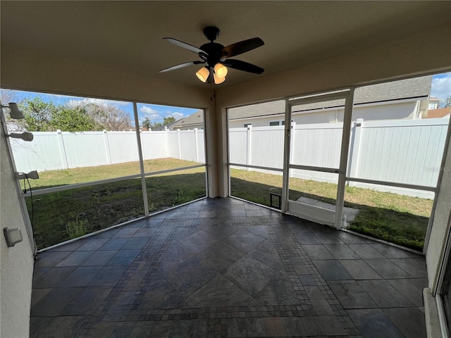 unfurnished sunroom featuring a ceiling fan