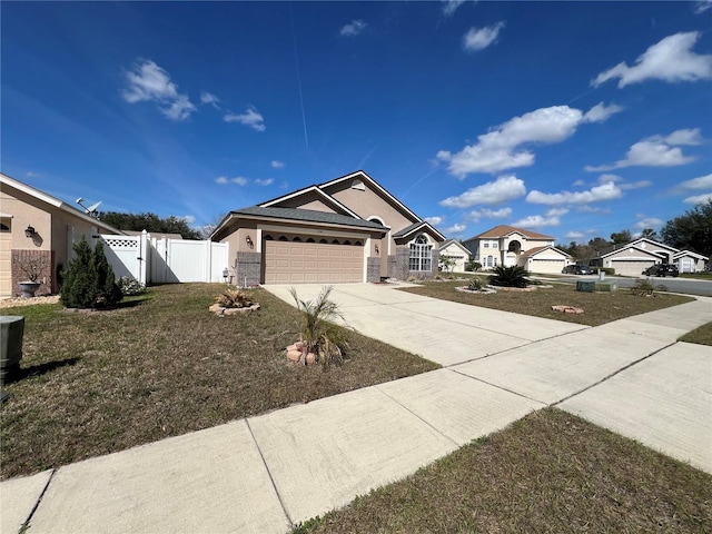 single story home with concrete driveway, an attached garage, a gate, fence, and stucco siding