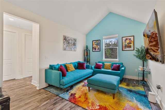 living area with lofted ceiling, baseboards, and wood finished floors