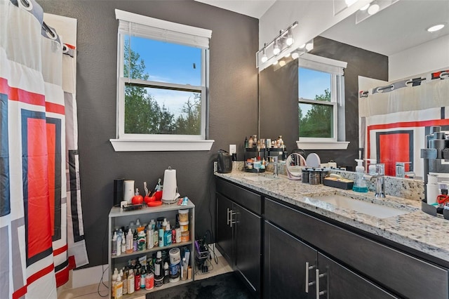 bathroom featuring double vanity, curtained shower, and a sink