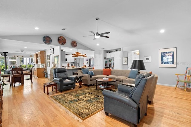 living room with light wood-style floors, lofted ceiling, and a ceiling fan