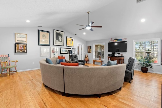 living room featuring light wood-style floors, baseboards, and vaulted ceiling