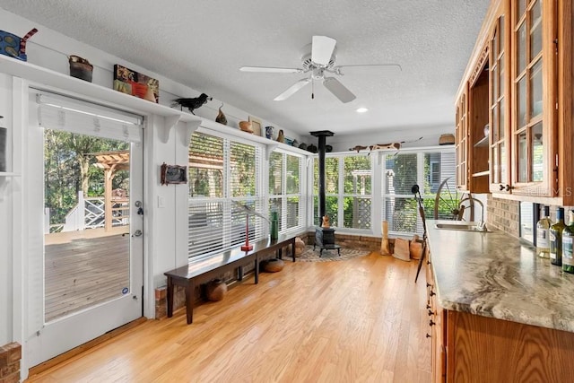 sunroom featuring ceiling fan and a sink