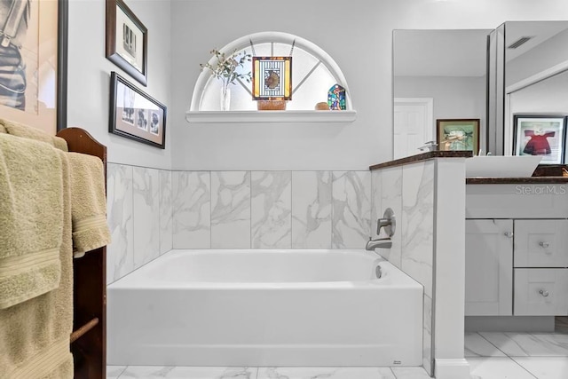 bathroom featuring marble finish floor, visible vents, vanity, and a bath