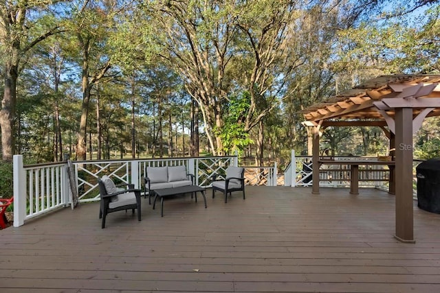 wooden deck featuring grilling area, an outdoor hangout area, and a pergola