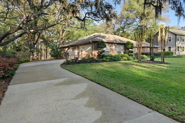 view of front of home with a front yard, concrete driveway, and brick siding