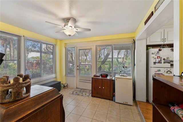 sunroom / solarium featuring a ceiling fan